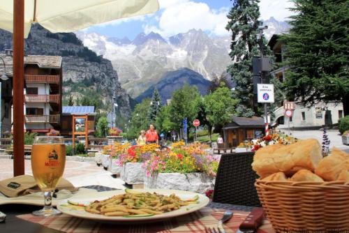a table with a plate of food and a glass of beer at La Maison Everest 73 - bilocale a La Ruine, Morgex in Morgex