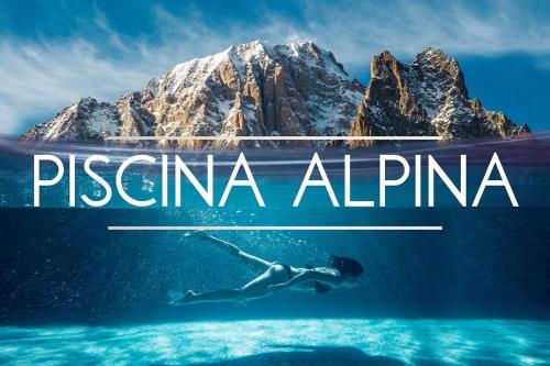 a woman swimming in the water in front of a mountain at La Maison Everest 73 - bilocale a La Ruine, Morgex in Morgex