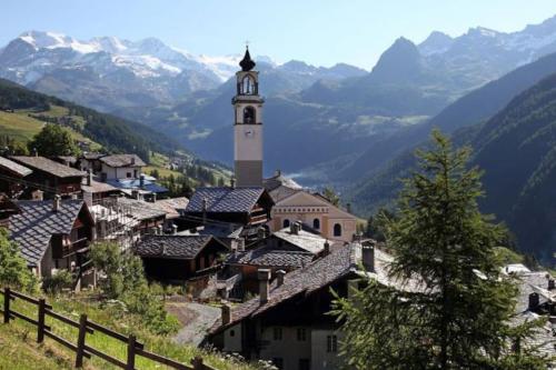 a small town with a clock tower in the mountains at La Maison Everest 73 - bilocale a La Ruine, Morgex in Morgex