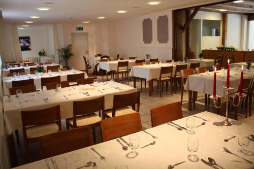 een eetkamer met tafels en stoelen met wijnglazen bij Hotel Engel in Emmetten