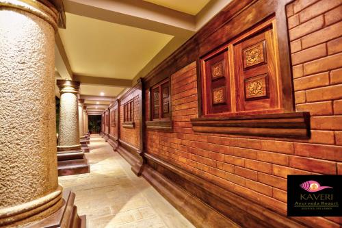a corridor of a building with a brick wall at Kaveri Resort Sigiriya in Sigiriya
