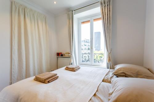 1 dormitorio con 2 camas y ventana en Cozy Studio With Amazing View en París