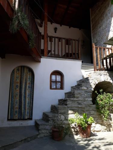 ein weißes Gebäude mit einer Treppe und einem Fenster in der Unterkunft Hostel Mangalem in Berat