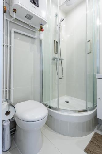 une salle de bain blanche avec douche et toilettes dans l'établissement Cozy Studio With Amazing View, à Paris