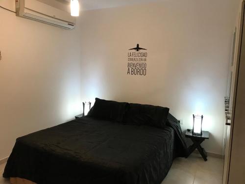 um quarto com uma cama e uma placa na parede em Departamento Moderno en el corazón de San Juan em San Juan