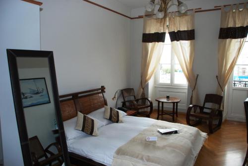 a bedroom with a bed with a mirror and a table at Hostellerie de Genève in Vevey