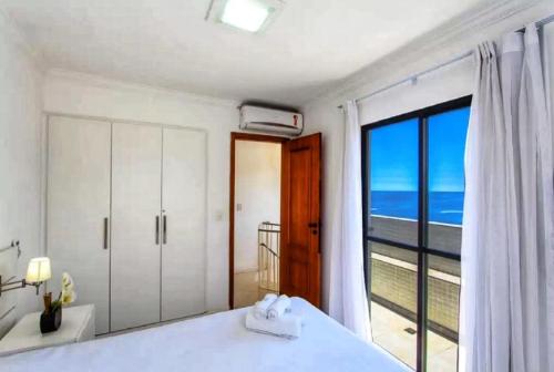 a bedroom with a large window with a view of the ocean at Seaview Penthouse Arpoador in Rio de Janeiro