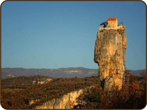 a rock pillar with a house on top of it at hotel in Chiatʼura