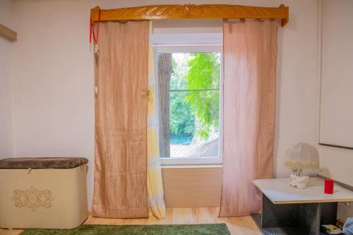a window with curtains in a room with a table at BuBu- Budapest Butterfly's in Budapest