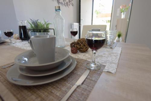a table with a cup of wine and two glasses of wine at Andriana' s apartment Agia Paraskevi in Athens