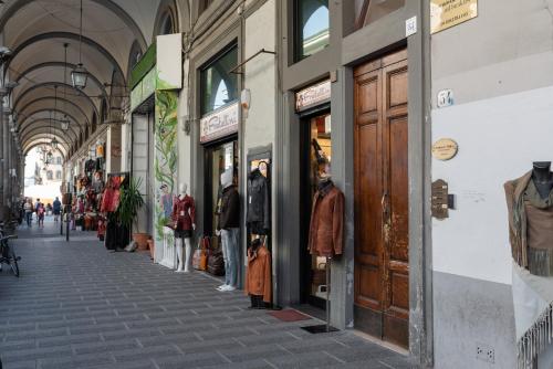 a street with a bunch of store fronts with people standing outside at B&B Lorenzo de' Medici in Florence