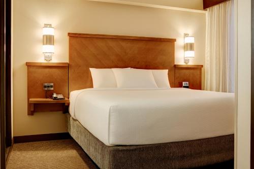 a bedroom with a large white bed and two lights at Hyatt Place Dallas/Garland/Richardson in Garland
