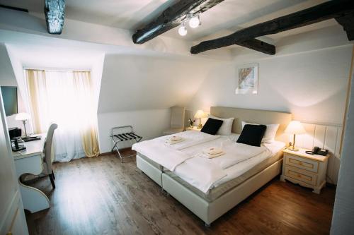 Schlafzimmer mit einem großen weißen Bett und einem Schreibtisch in der Unterkunft Hotel Gasthaus Papen Änne in Kassel