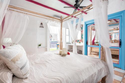 um quarto com uma cama de dossel e cortinas brancas em Los MOXAICOS, TENERIFE em Costa Del Silencio