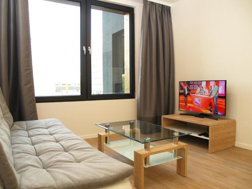 un soggiorno con divano e TV di Elegant Apartment Miletičova, Free Parking a Bratislava