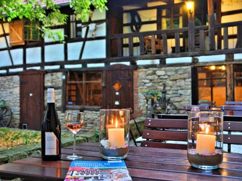 - une bouteille de vin et des bougies sur une table en bois dans l'établissement Hotel Mohrenbrunnen, à Eisenberg