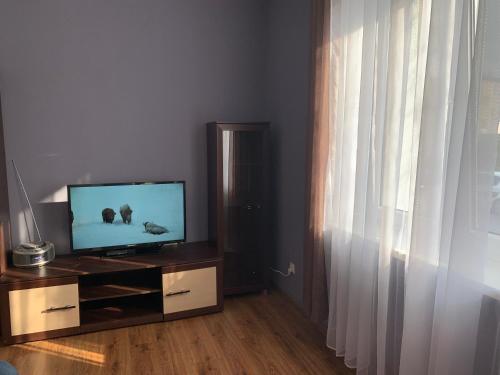 una sala de estar con TV de pantalla plana en una cómoda en Apartament Leśne, en Bydgoszcz