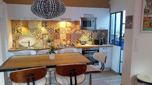 une cuisine avec une table et des chaises en bois dans l'établissement Villa Kady - Chalet de charme du 19ième siécle, à Le Touquet-Paris-Plage