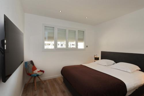 une chambre avec un grand lit et une chaise dans l'établissement Excellent Appt 2 pièces Super Croisette, à Cannes