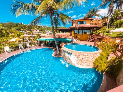 a pool at a resort with palm trees at La Boheme Hotel e Apart Hotel in Búzios