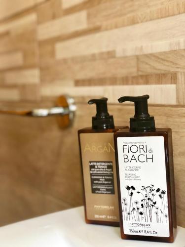 two bottles of hairbrushes sitting on a bathroom counter at Montellinos Suite Tortora in SantʼAntìoco