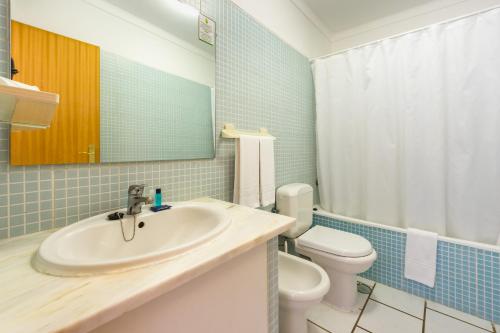 een badkamer met een wastafel en een toilet bij Club Ouratlantico in Albufeira