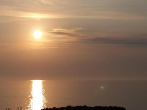 a sunset over the ocean with the sun in the sky at Queen Apartments & Rooms in Dobra Voda