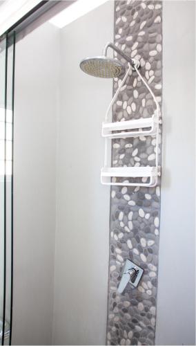 a shower with a rock wall in a bathroom at Palm Cottage in Durban