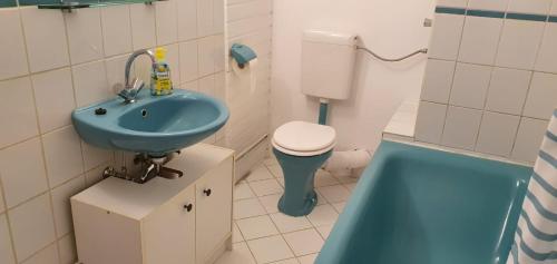 ein Badezimmer mit einem blauen Waschbecken und einem WC in der Unterkunft Ferienwohnung Leo Duisburg - Nähe Bahnhof in Duisburg