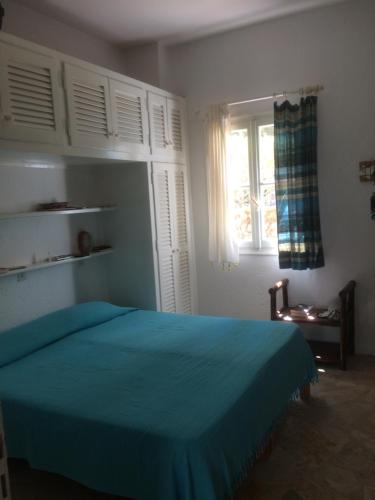 a bedroom with a blue bed and a window at Alexandra villas in Gouvia