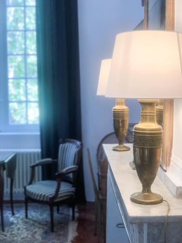 a lamp sitting on a table with a chair at Château de Saint-Girons - Luxury Guest House in Provence in Aix-en-Provence