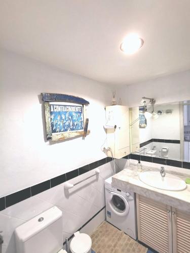 a bathroom with a white toilet and a sink at casa MarDolomiti in Corralejo