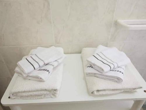 zwei weiße Handtücher auf einem weißen Tisch im Bad in der Unterkunft Vento di Scirocco in Pozzallo