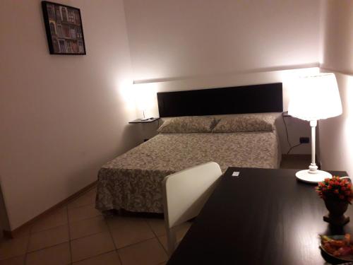 a bedroom with a bed and a lamp at Fontanarossa Airport Home in Catania