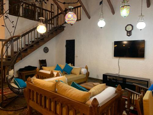 a living room with two couches and a tv at Villa Ameera Malindi in Malindi