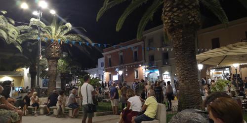 a crowd of people walking down a street at night at Sunny garden house in Villasimius