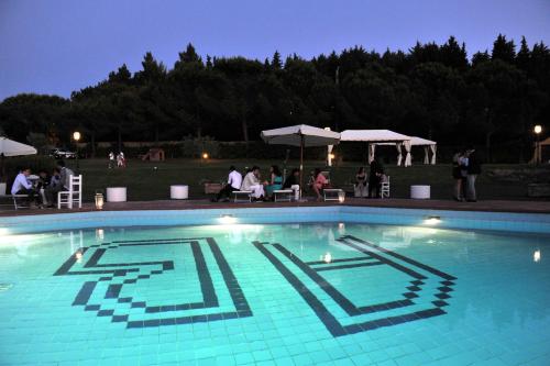 a large blue swimming pool with people sitting around at Agriturismo Bellavista in San Miniato