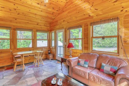 a living room with a couch and a table at Adirondack Adventuring in Brant Lake