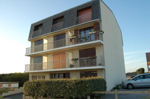 a building with a car parked in front of it at Appartement Vivacances côte d'Opale (Ste-Cécile) in Camiers