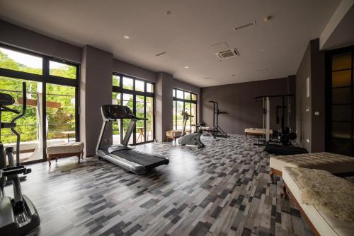 a gym with several exercise equipment in a room with windows at Hotel Kostelski Buk in Bihać