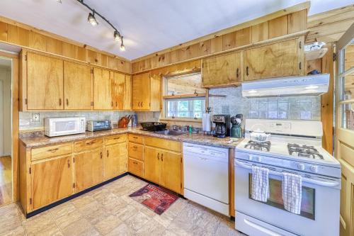 a kitchen with wooden cabinets and white appliances at Adirondack Adventuring in Brant Lake