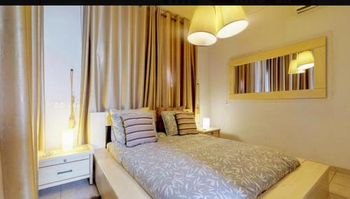 a bedroom with a bed with pillows and a window at השכרה וסבלט בקומפלקס של יחידות in Mitzpe Ramon