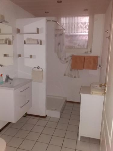 a white bathroom with a tub and a sink at Ferienwohnung Reuter in Niederzissen