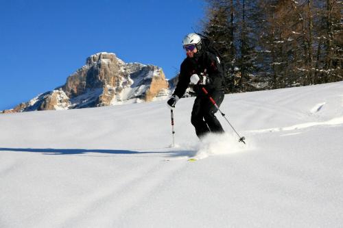 a person is skiing down a snow covered slope at Hotel Ciasa Ai Pini in San Cassiano