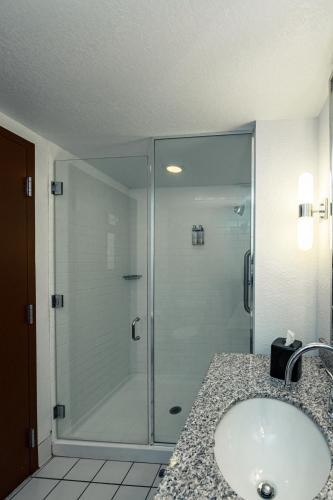 a bathroom with a glass shower and a sink at SEVEN Sebring Raceway Hotel in Sebring