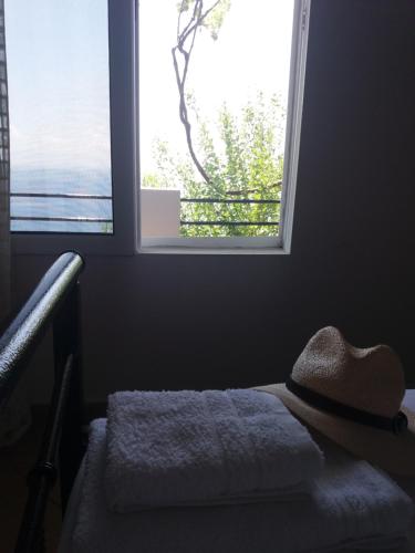 a hat sitting on a bed in front of a window at Blue View in Qeparo