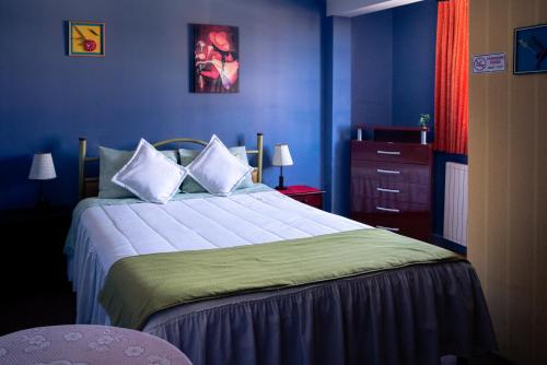 1 dormitorio con 1 cama grande y paredes azules en Tonito Hotel en Uyuni