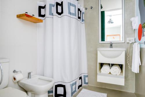 y baño con aseo y cortina de ducha. en Selina Nueva Cordoba en Córdoba