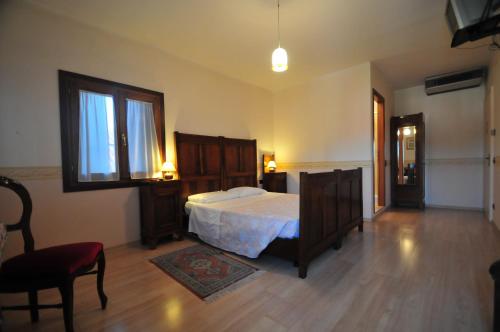 a bedroom with a bed and a chair and a window at Locanda Sant'Anna Hotel in Venice