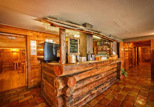 a wooden bar with a tv on top of it at Hôtel & Spa La Ferme de l'Izoard in Arvieux
